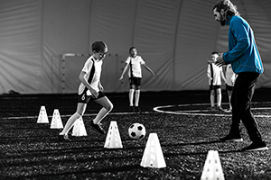 Child Dribbling Through Cones