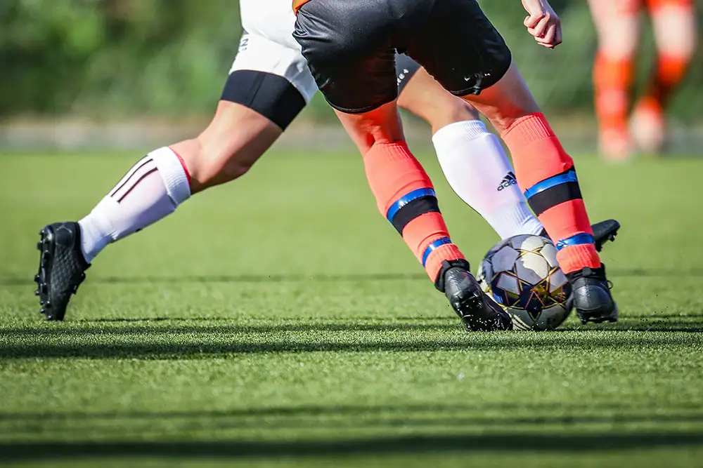 Legs of Footballers tackling during a match